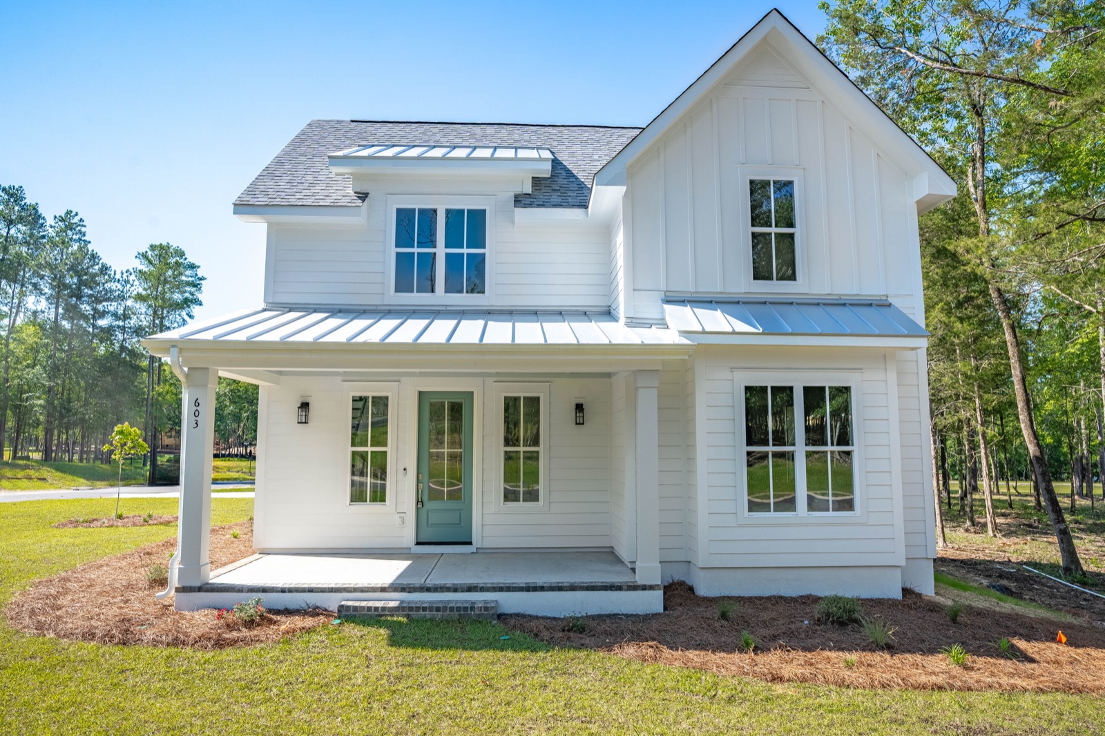 603 Misty Banks Drive, a white farmhouse with a standing seam porch roof